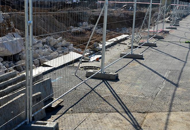 a temporary job site fence panel with orange safety mesh